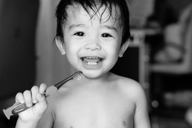 kid boy brushing teeth and smiling